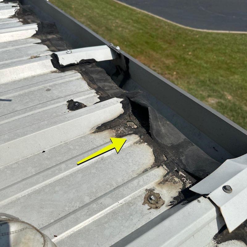 Metal roof seam with damaged sealant and corrosion