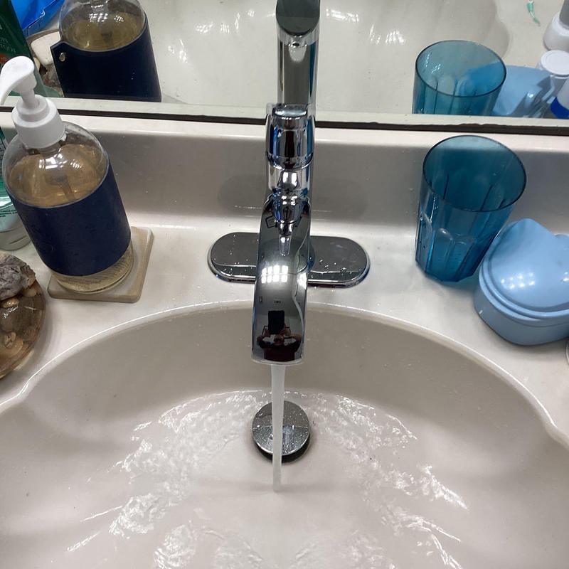 Lavatory faucet with running water in bathroom sink