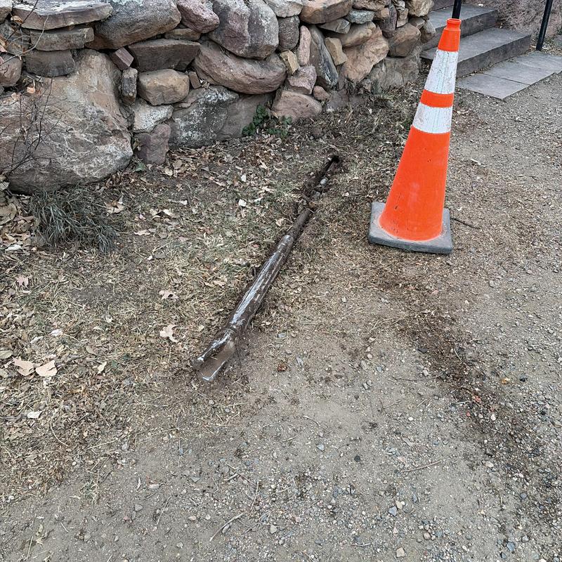 Utility pipe installation in rocky soil beside stone wall Utility pipe installation in rocky soil beside stone wall