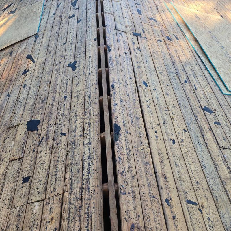 Wooden roof planks with gaps before sheathing installation Wooden roof planks with gaps before sheathing installation