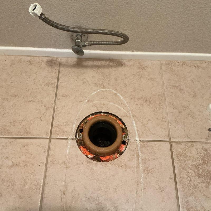 Toilet flange on tiled floor with supply line disconnected