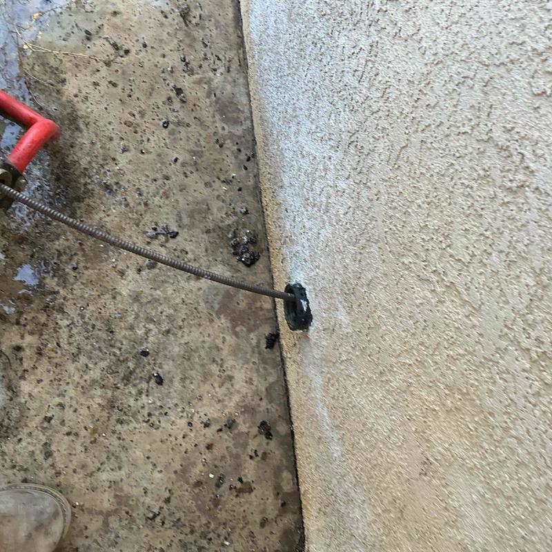 Kitchen sink drain line being snaked to clear clog