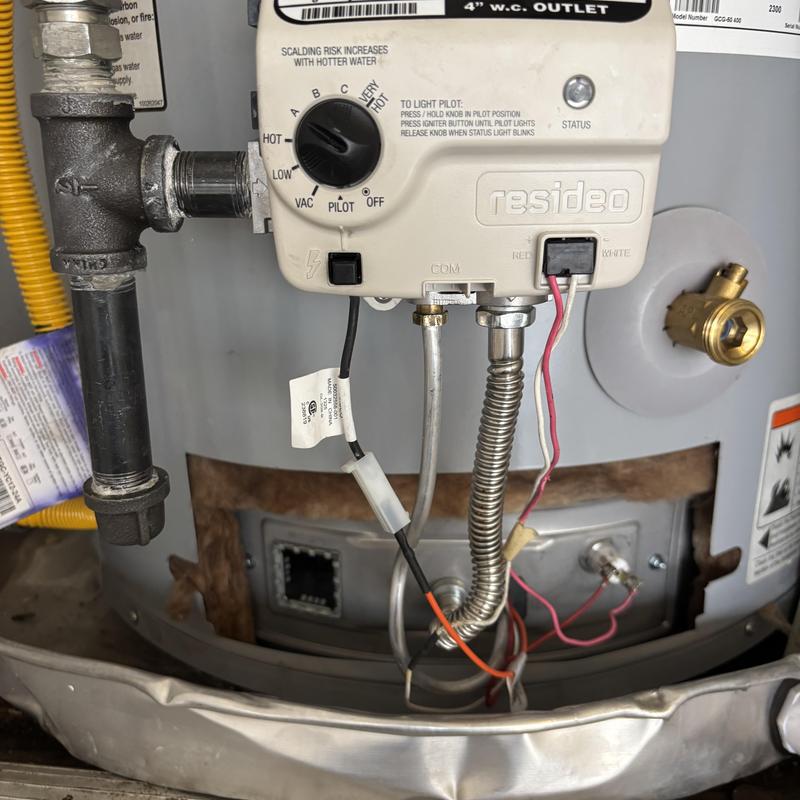 Gas control valve on water heater with wiring and pipes