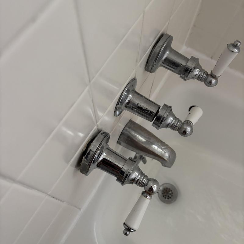 Bathtub faucet and handles on tiled wall