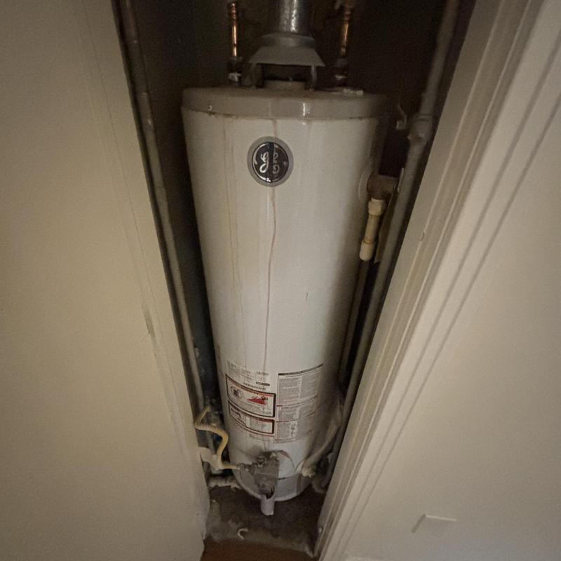 Water heater with rust stains in narrow closet space