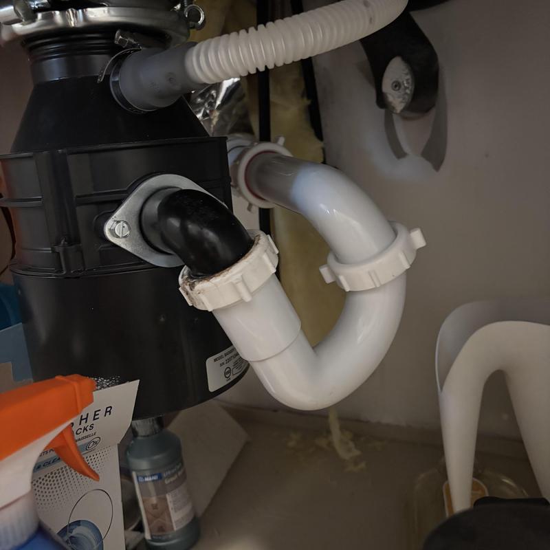 Garbage disposal drain pipes under sink in Dallas