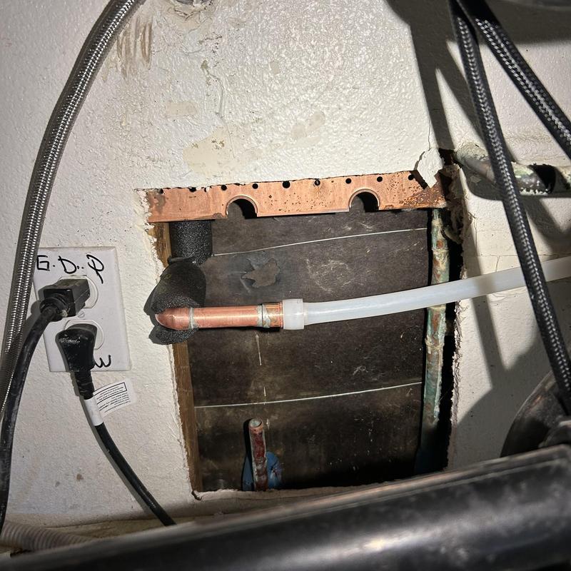 Copper waterline reroute with new plastic tubing inside wall