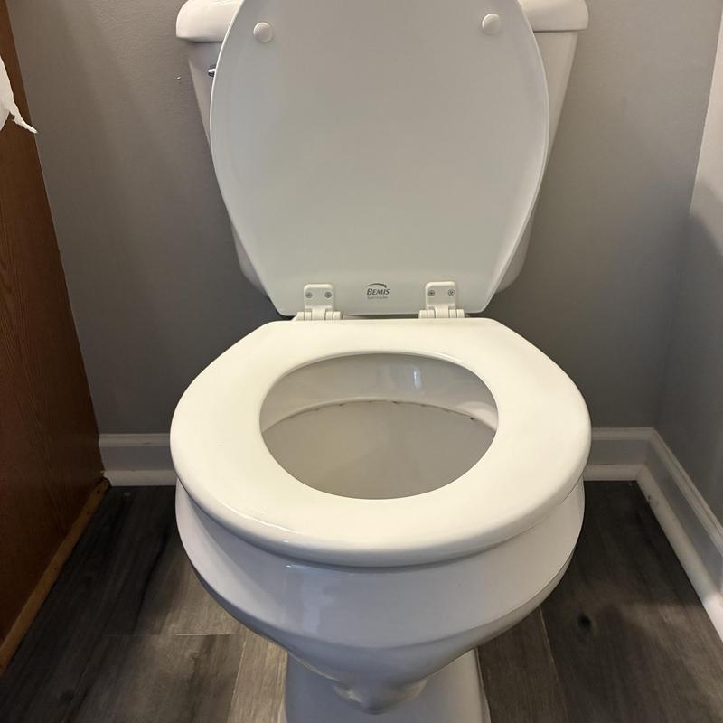 Round bowl toilet with standard height seat installed