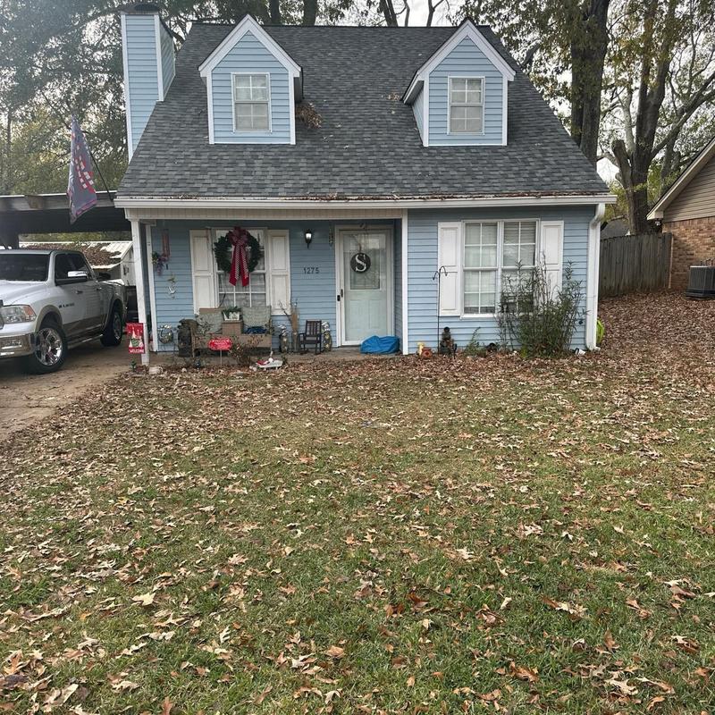 Roof shingles inspection on blue two-story house