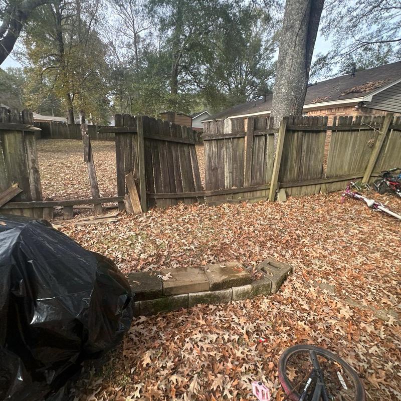Wooden fence with damaged and missing panels in yard