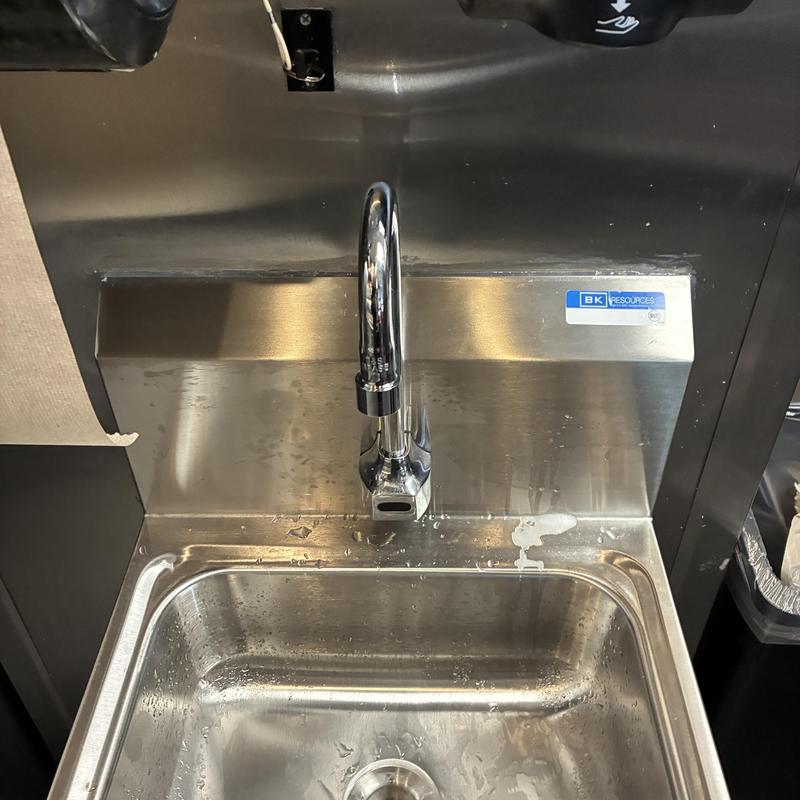 Wall-mounted hand sink with hands-free faucet in kitchen