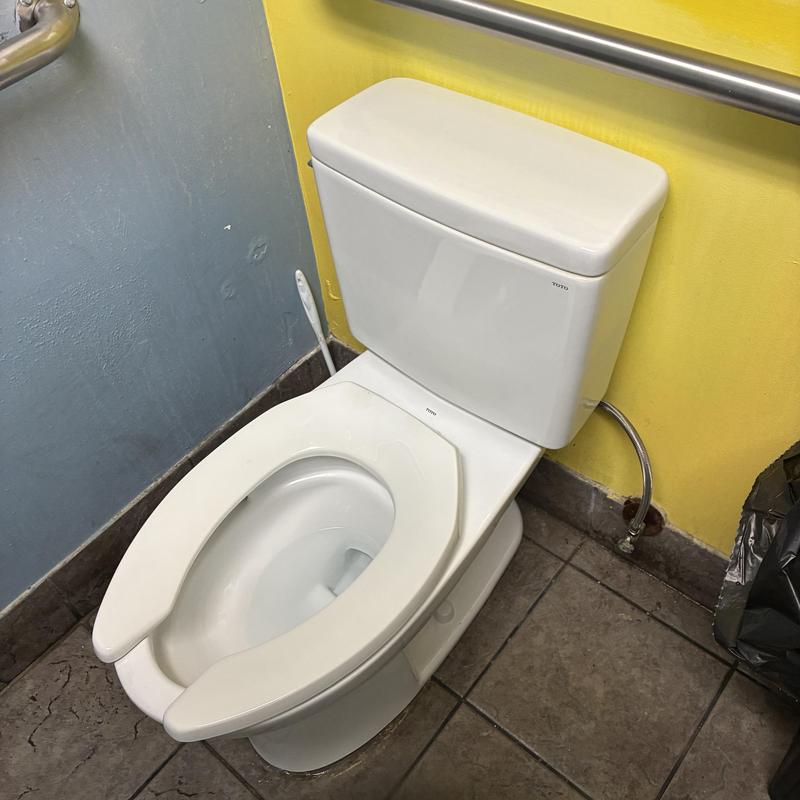 Toilet installation in office bathroom with safety bar