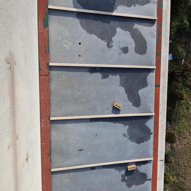 Metal roof panels with hail damage and water stains