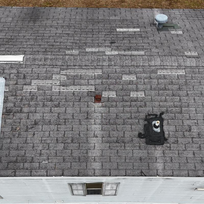 Asphalt shingle roof with ventilation pipes and patches