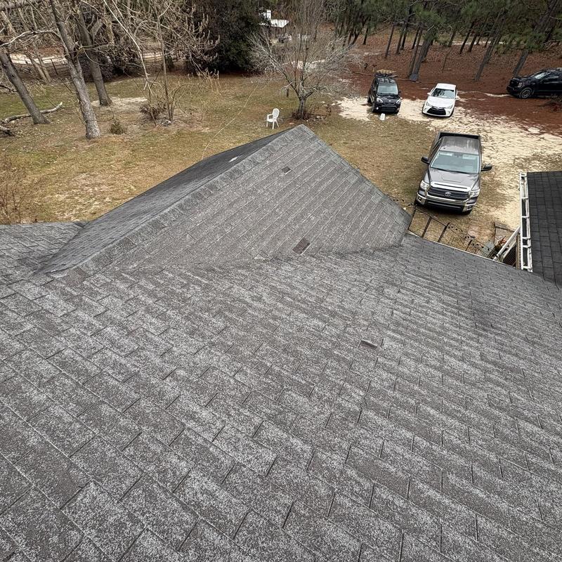 Asphalt shingle roof with visible wind damage and wear