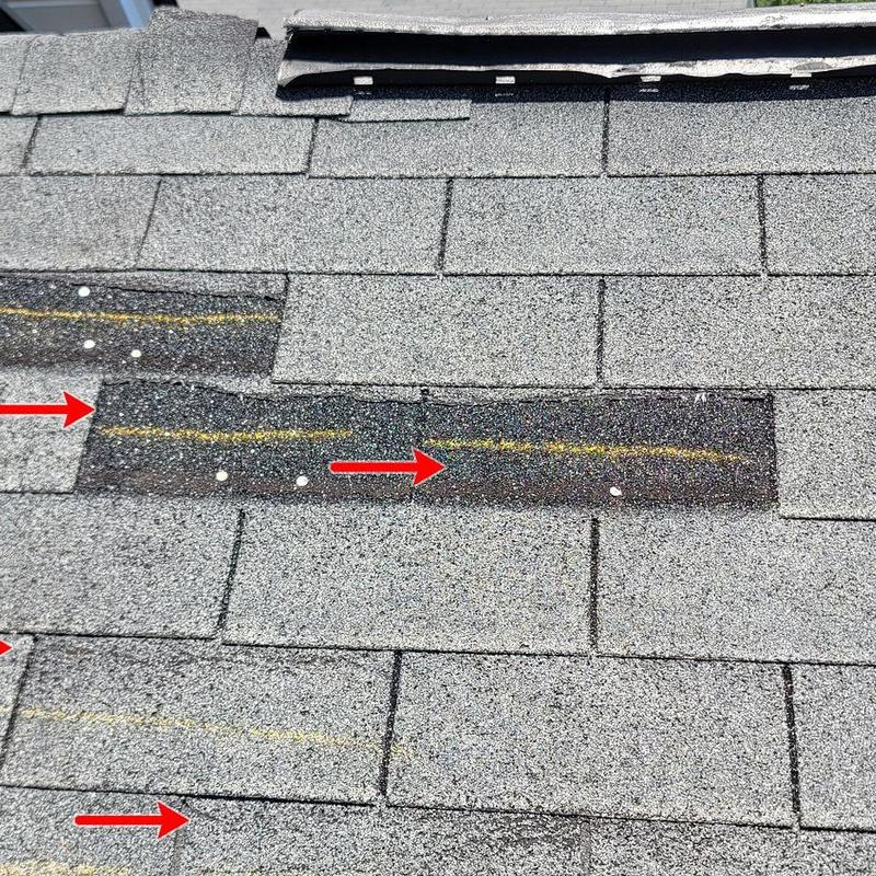 Asphalt roof shingles with impact damage markings
