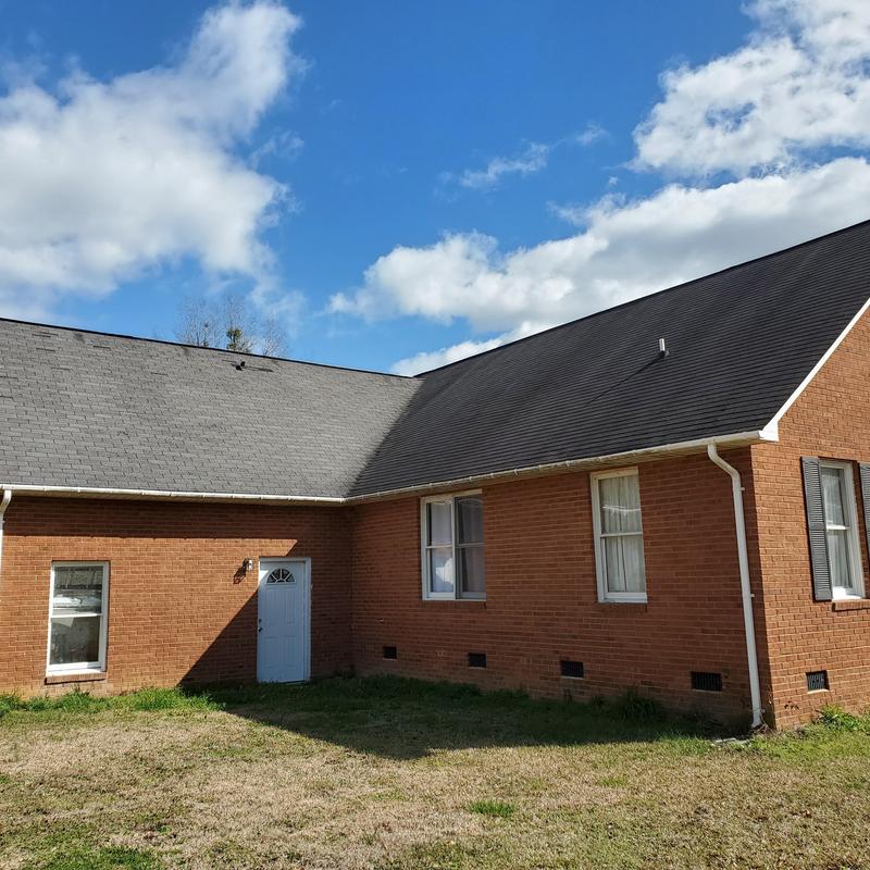 Asphalt shingle roof with wind damage covered by insurance