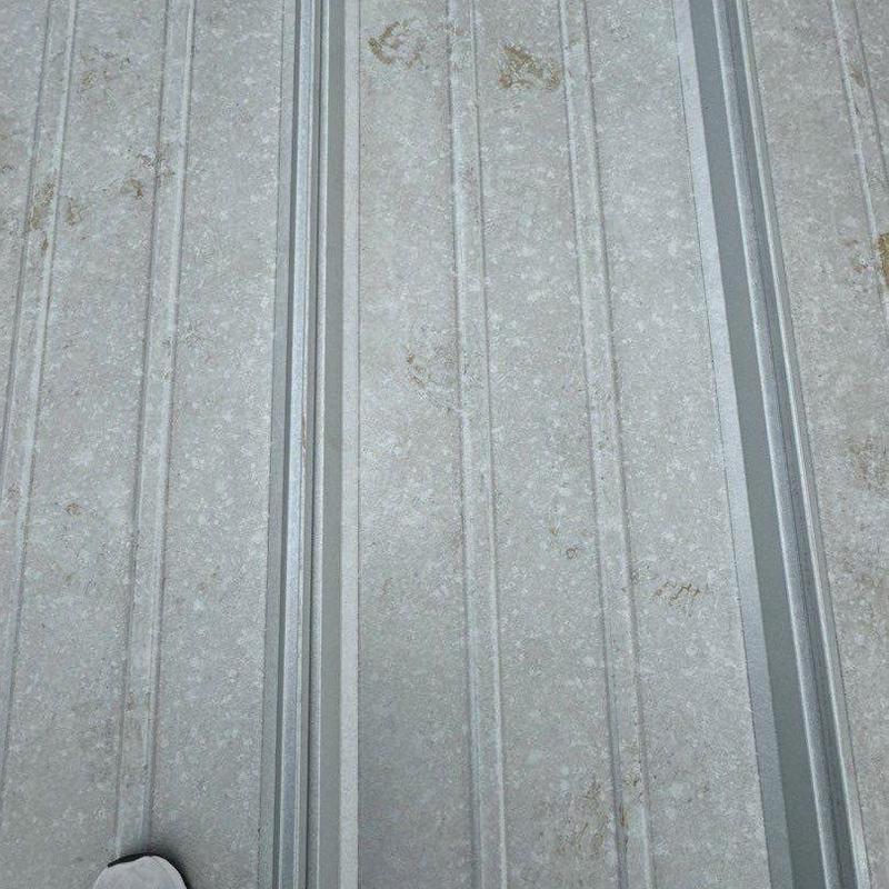 Metal roof panel close-up with dirt marks