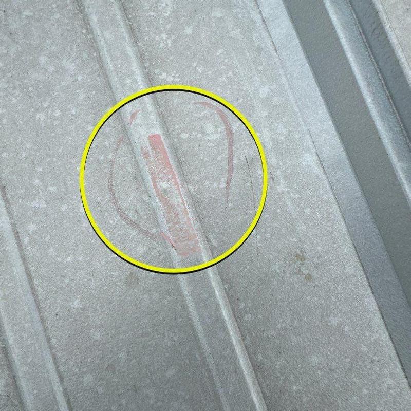 Metal roof panel with marked damage after storm