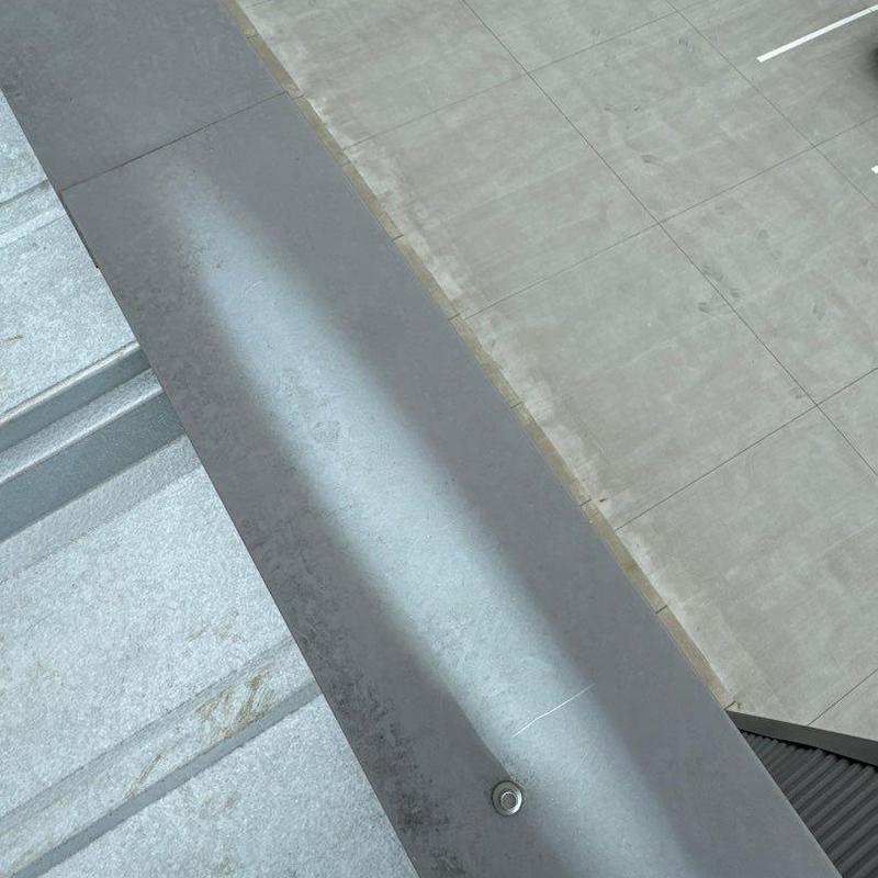 Metal roof flashing with fastener on rooftop edge