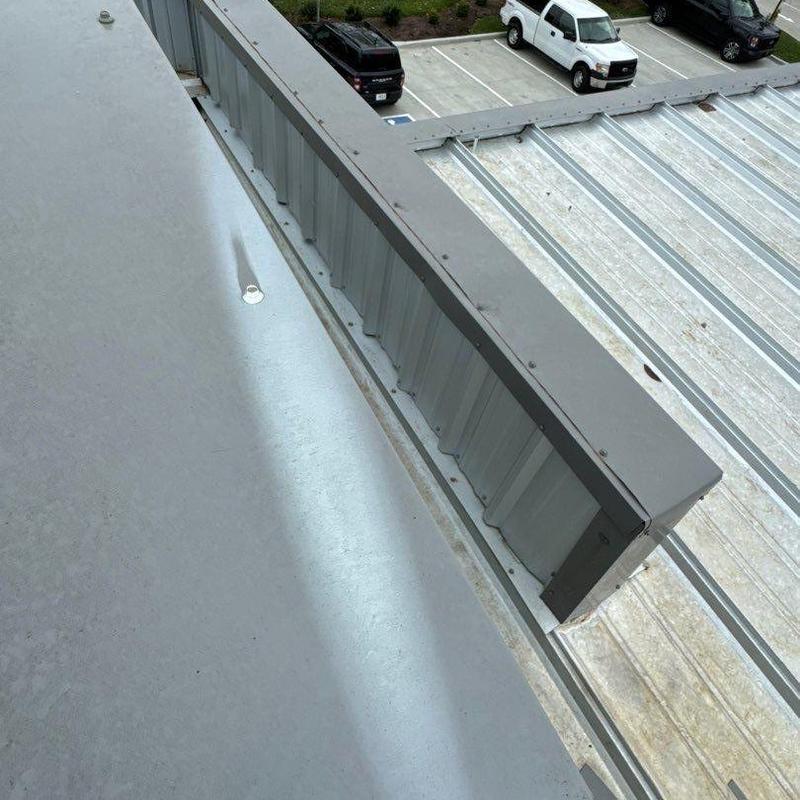 Metal roof flashing along building edge after storm inspection