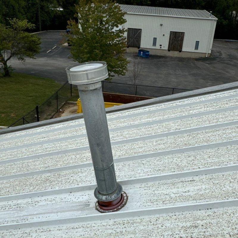Metal roof vent pipe flashing on white roof panels