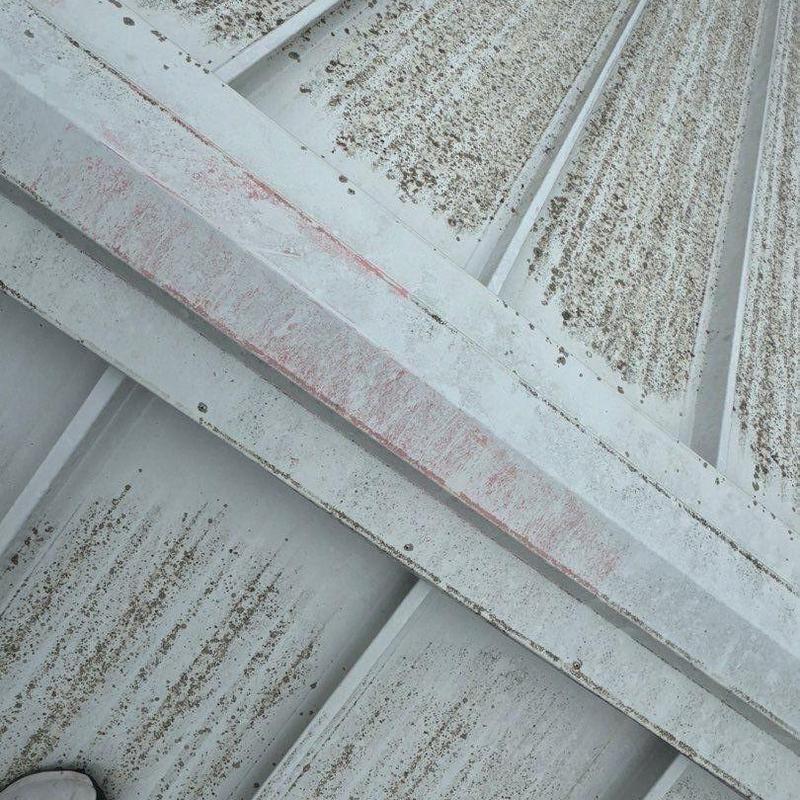 Metal roof panels with rust and dirt buildup