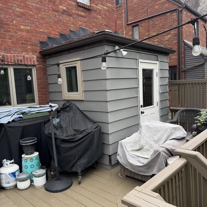 Exterior siding and trim installation on patio shed