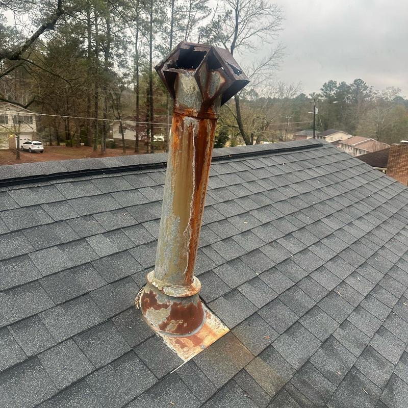 Rusted HVAC exhaust vent pipe on shingled roof Rusted HVAC exhaust vent pipe on shingled roof