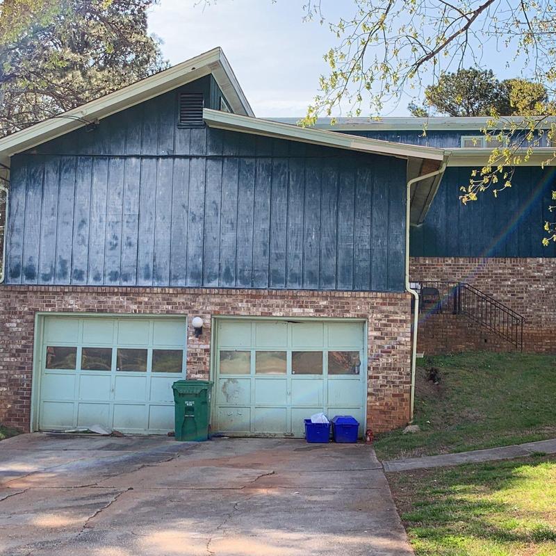 Garage doors on brick house with cracked driveway Garage doors on brick house with cracked driveway