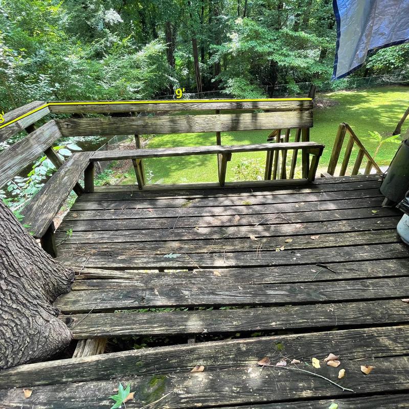 Wooden deck with damaged floorboards and railing Wooden deck with damaged floorboards and railing