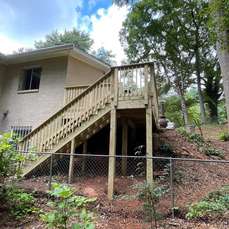 Custom-built wooden deck and stairs at backyard slope Custom-built wooden deck and stairs at backyard slope