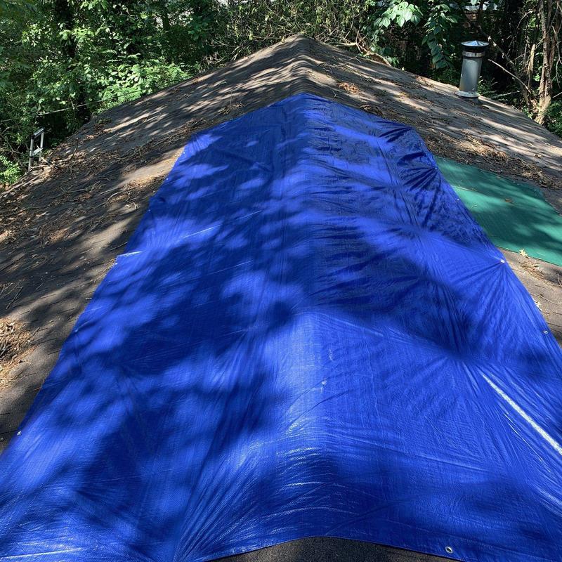 Roof tarp covering damaged shingle area on residential home Roof tarp covering damaged shingle area on residential home