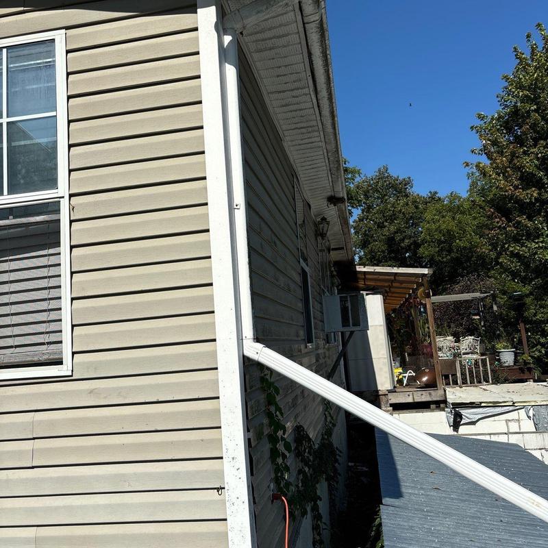 Vinyl siding with gutter downspout on house exterior