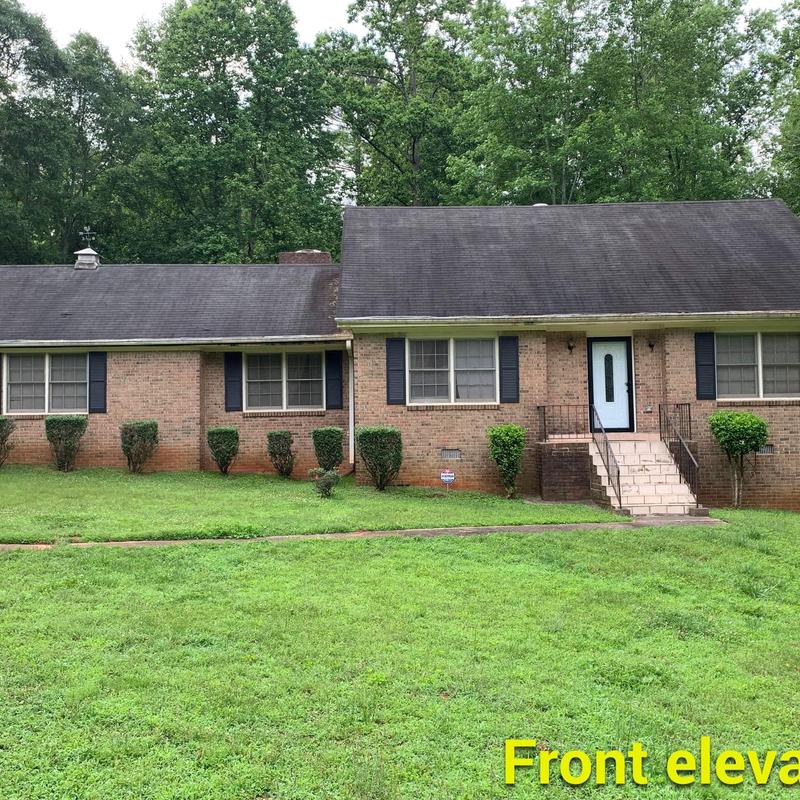 Roof with black shingles on brick house exterior Roof with black shingles on brick house exterior