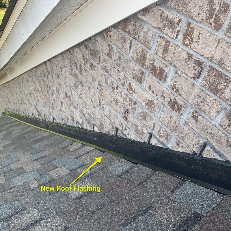 Roof flashing installation on asphalt shingle roof near brick wall Roof flashing installation on asphalt shingle roof near brick wall