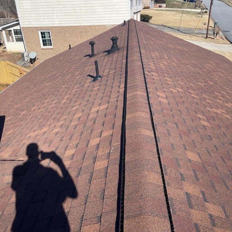 Atlas Burnt Sienna shingles on residential roof ridge Atlas Burnt Sienna shingles on residential roof ridge