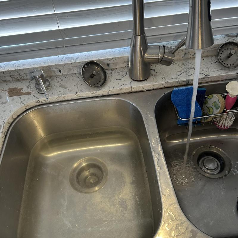 Kitchen sink drain with flowing water and cleaning items