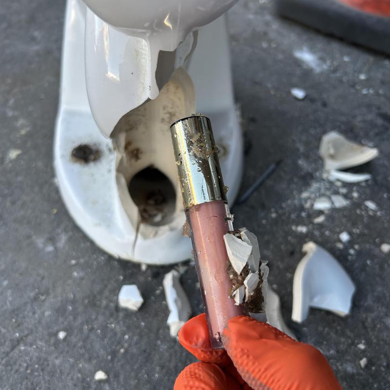 Toilet bowl with broken porcelain and removed obstruction