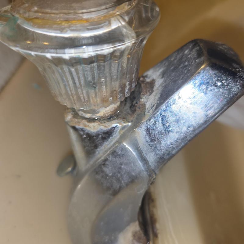 Bathroom faucet with mineral buildup and corrosion detail