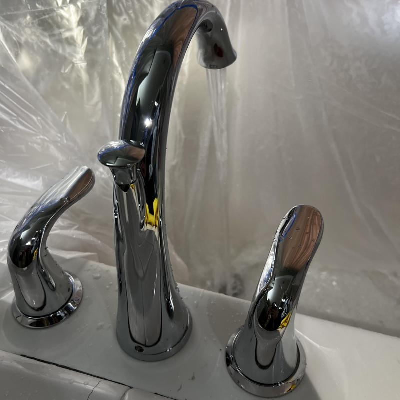 Roman tub valve with chrome handles and running water