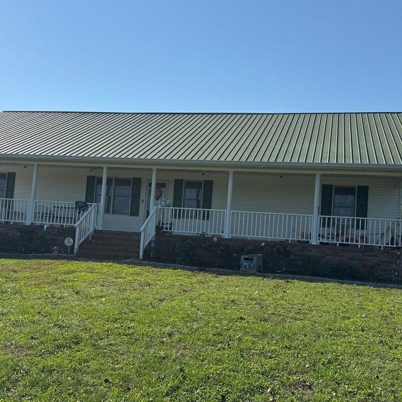 Metal roof on residential house with porch and lawn