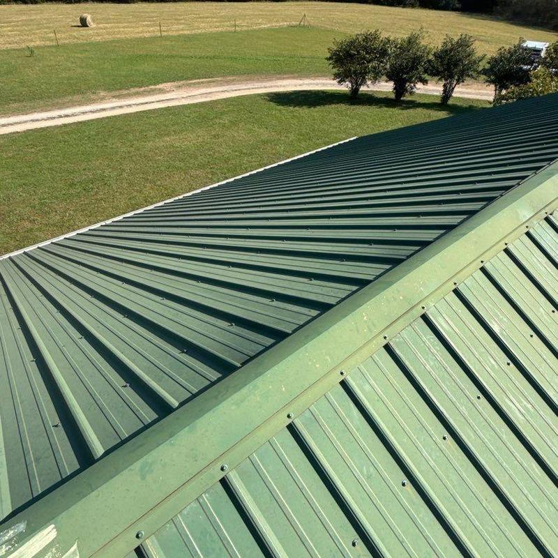 Metal roof panels with ridge cap on residential building