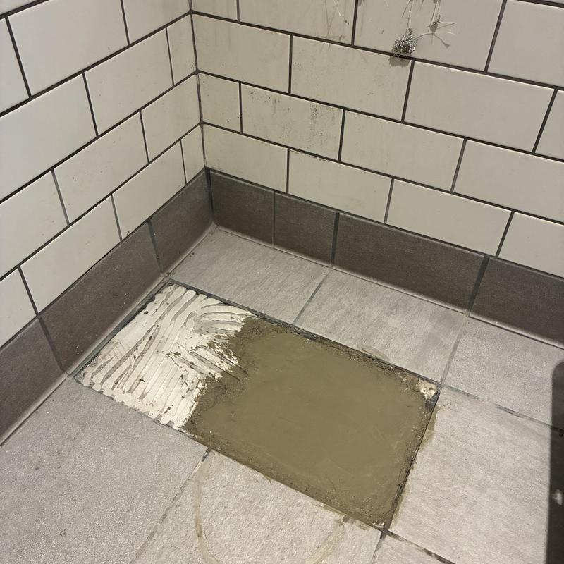 Bathroom floor tile patch with fresh mortar filling