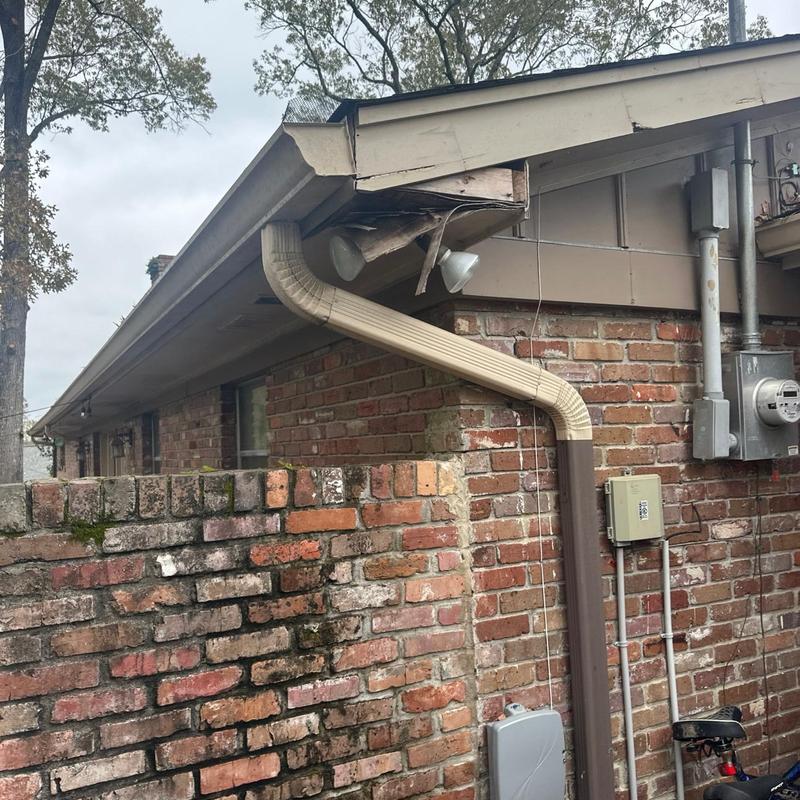 Soffit with damaged fascia and gutter downspout