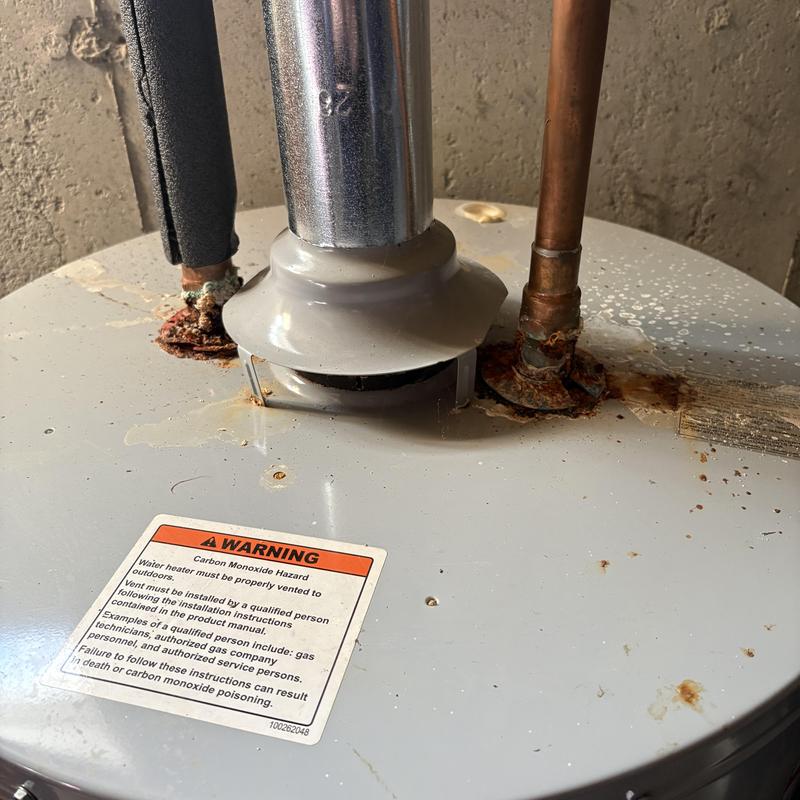 Natural gas water heater top with rust and pipes