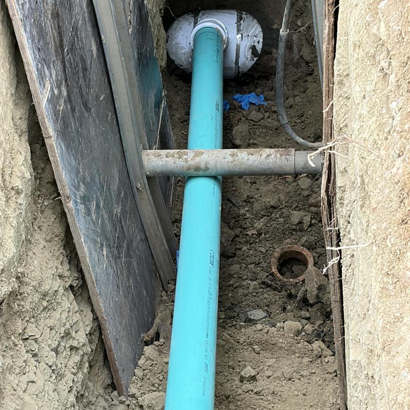 PVC sewer line installation in trench with soil backfill PVC sewer line installation in trench with soil backfill