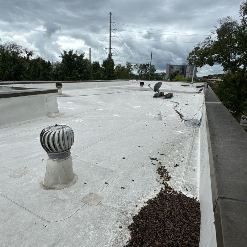 Flat commercial roof with vent turbine and debris buildup