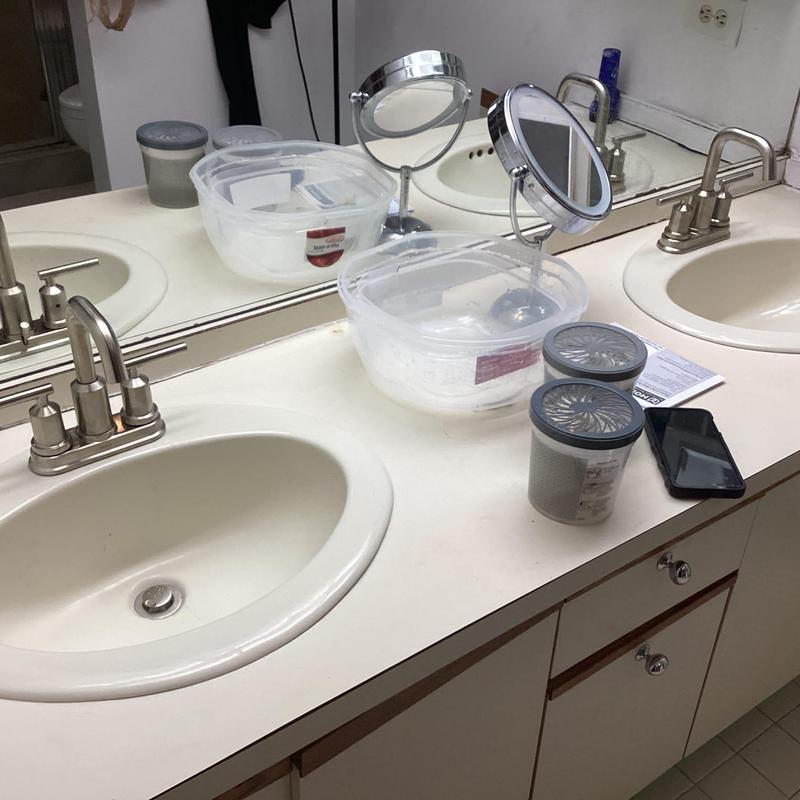 Lavatory faucets with beige countertop and mirror