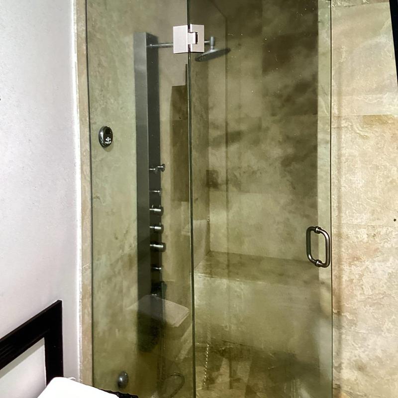 Shower tower with multiple spray nozzles in glass shower